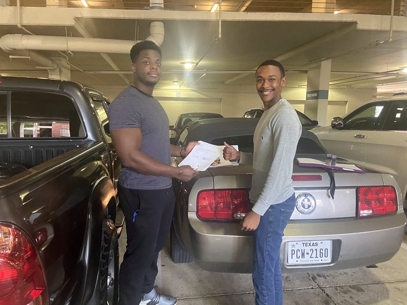 Auto title notary signing in a Houston parking garage